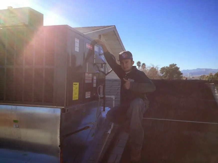 HVAC technician performing Air Duct Repair on a rooftop unit in Parkville